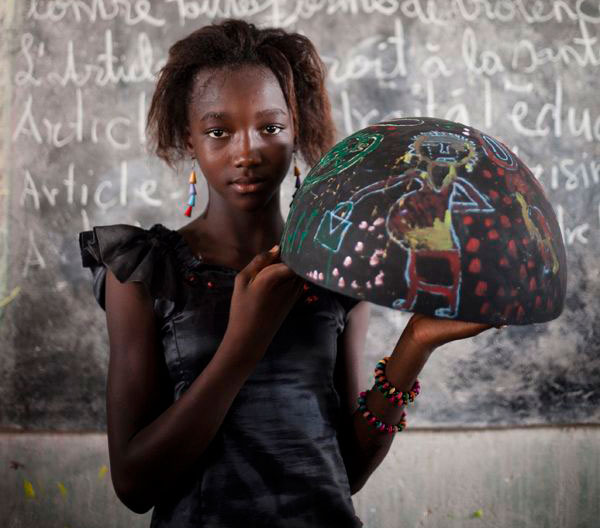 girl from Senegal holding painted bowl