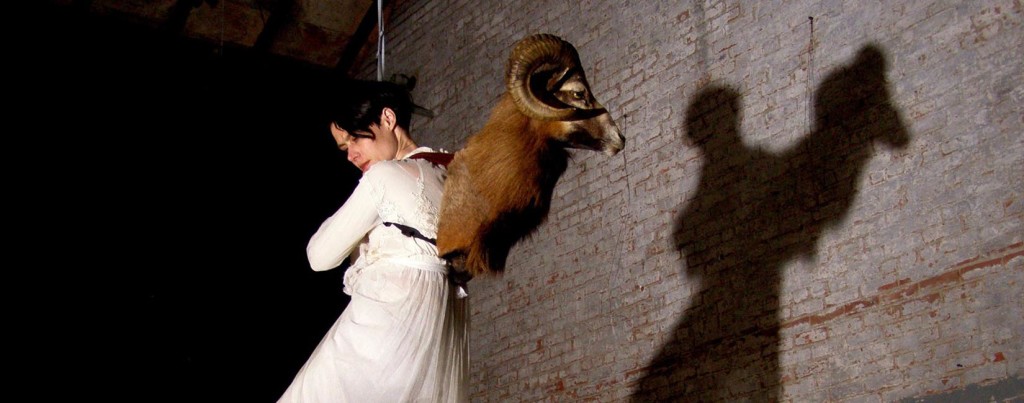 Suspended woman with ram's head on her back