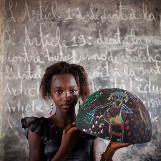 girl from Senegal holding painted bowl