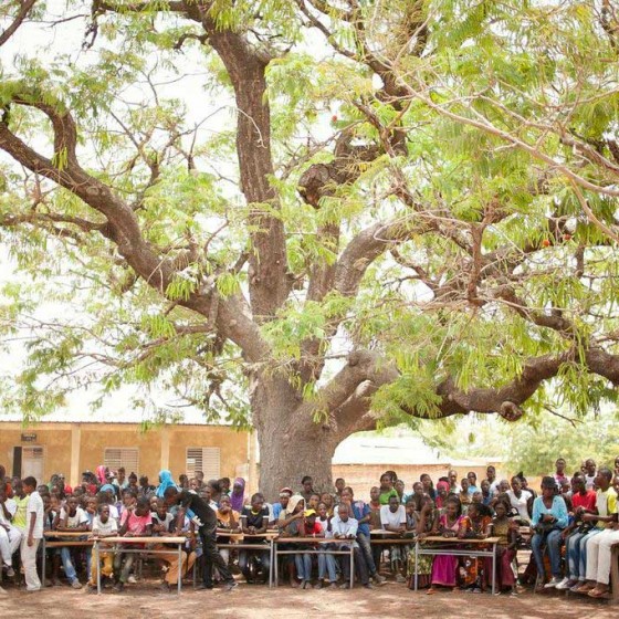 teachers and students from Senegal sitting in front of school