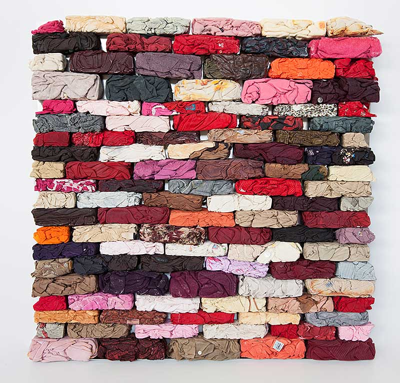 sculpture in form of brick wall made from discarded textiles