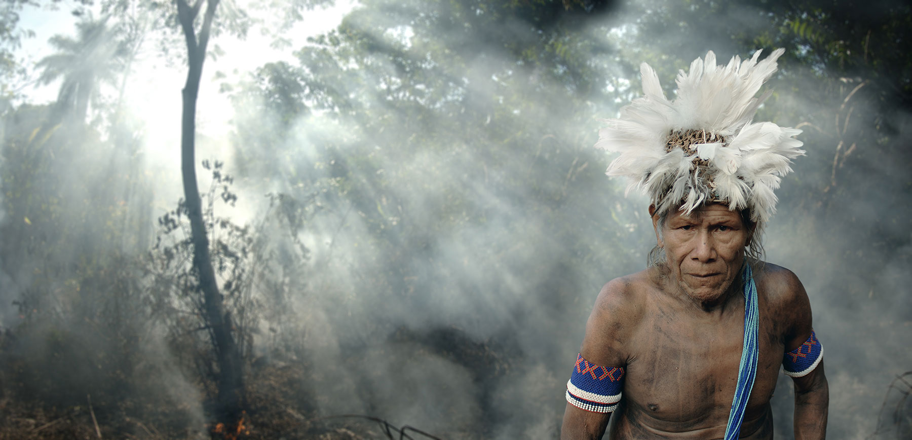 indigenous man in smokey forest