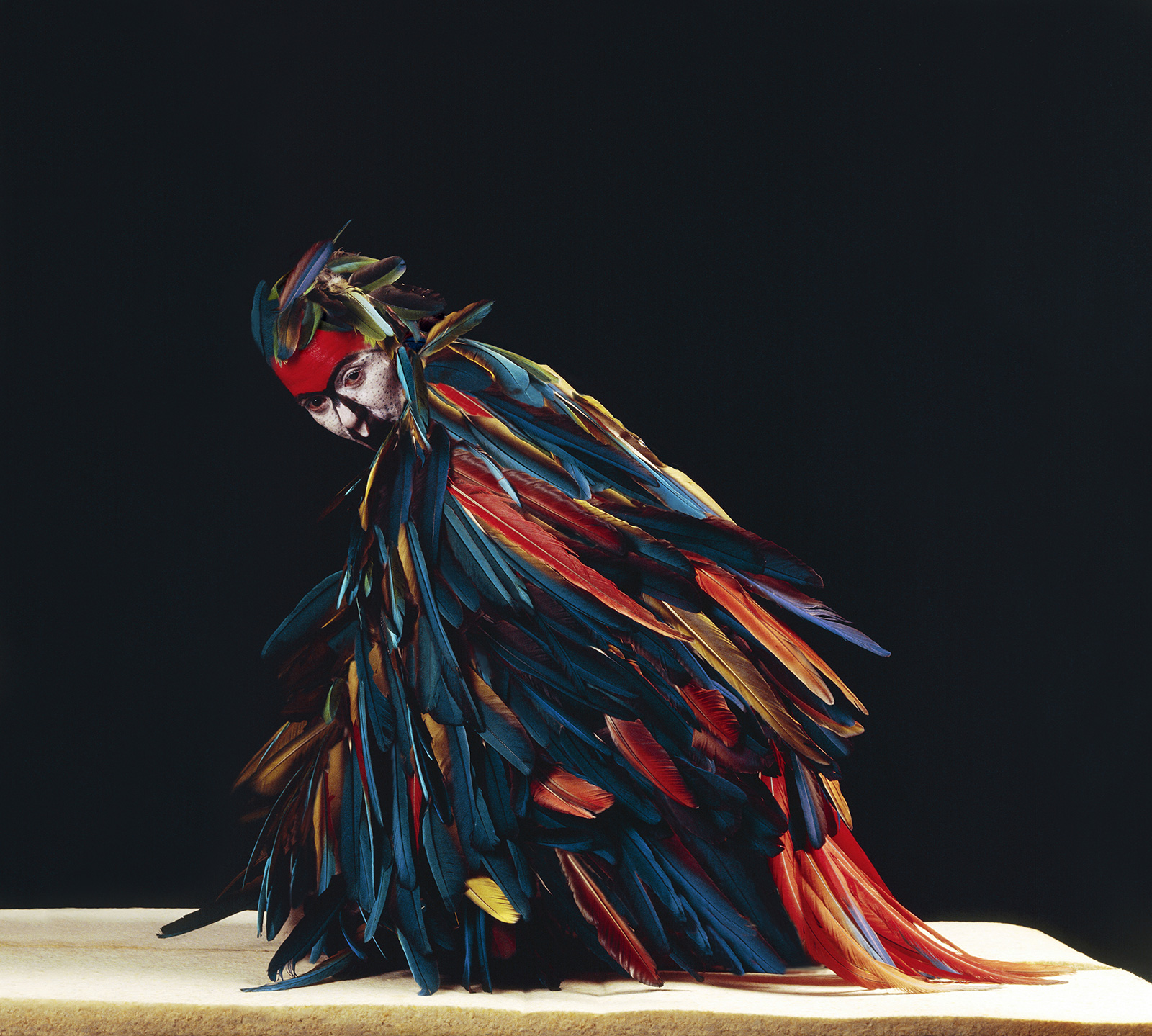 woman covered with feathers in performance pose
