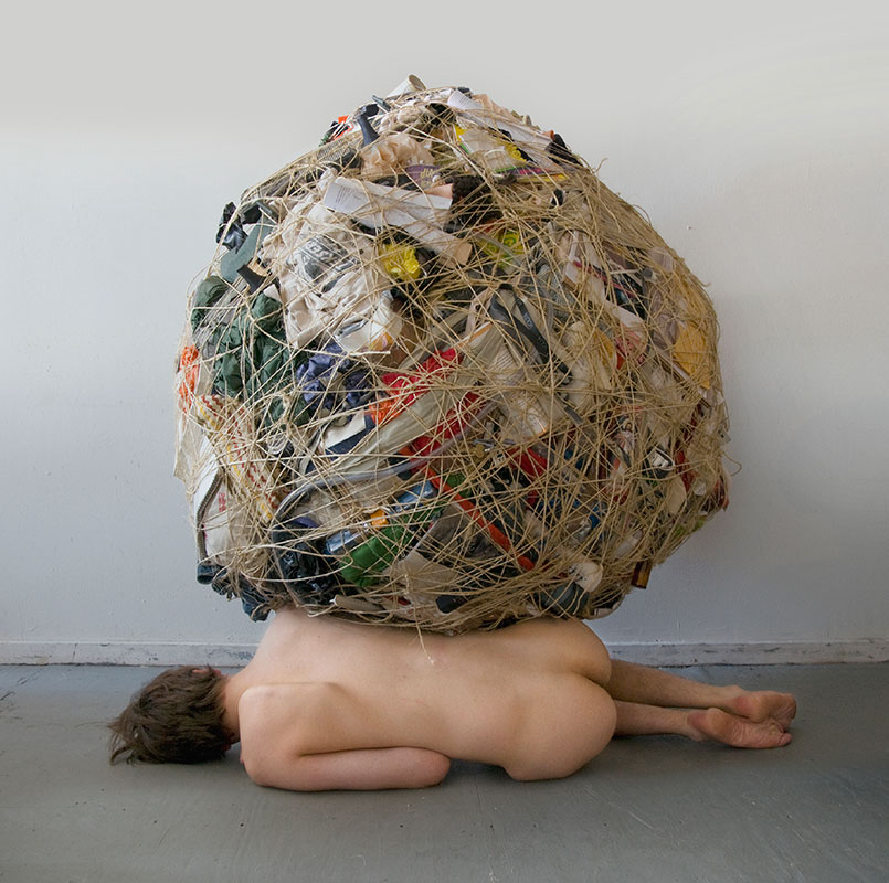 ball of possessions sitting on top of nude woman