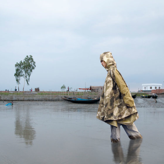 woman wading in water wearing portable shelter jacket