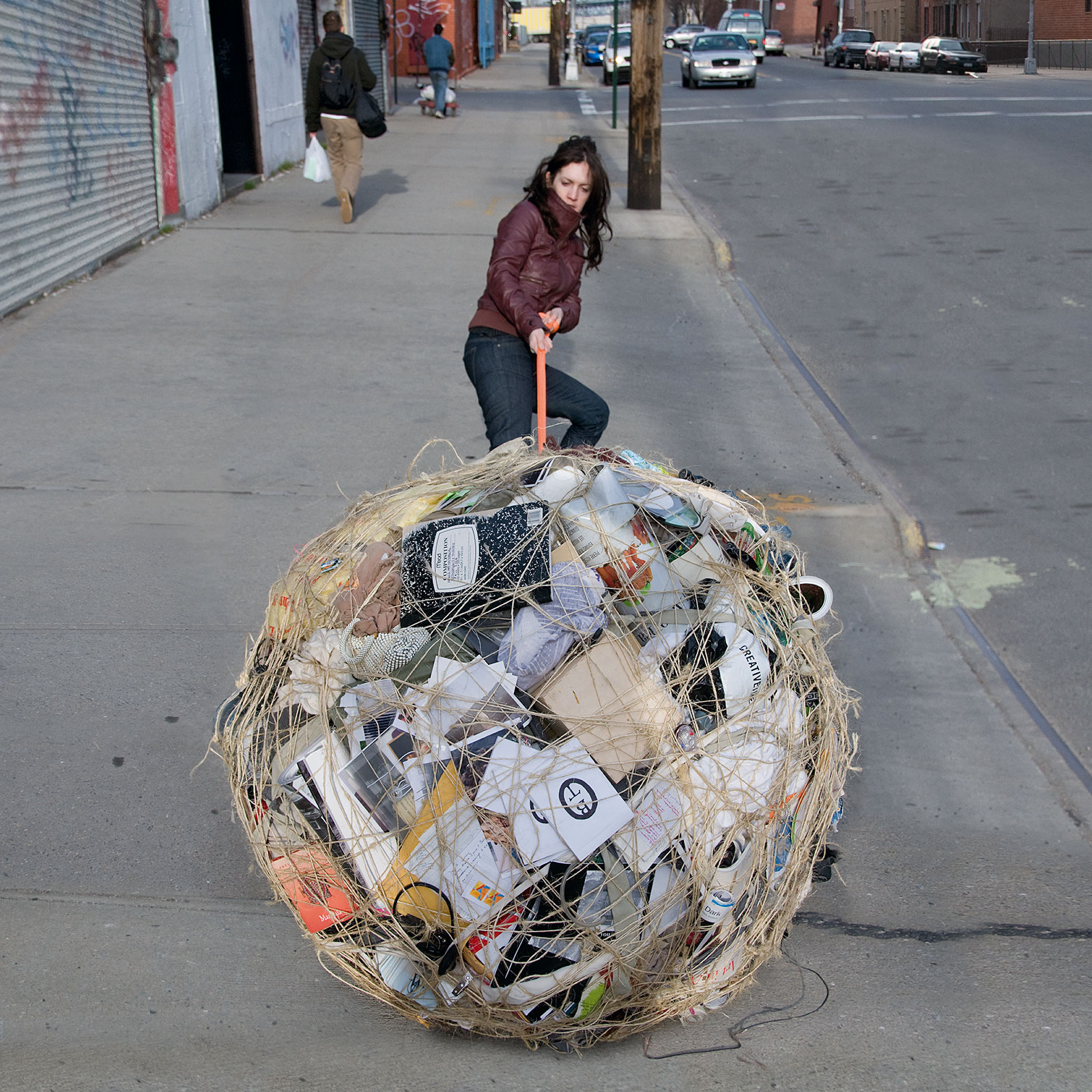 woman pulling bundle of possessions tied with twine