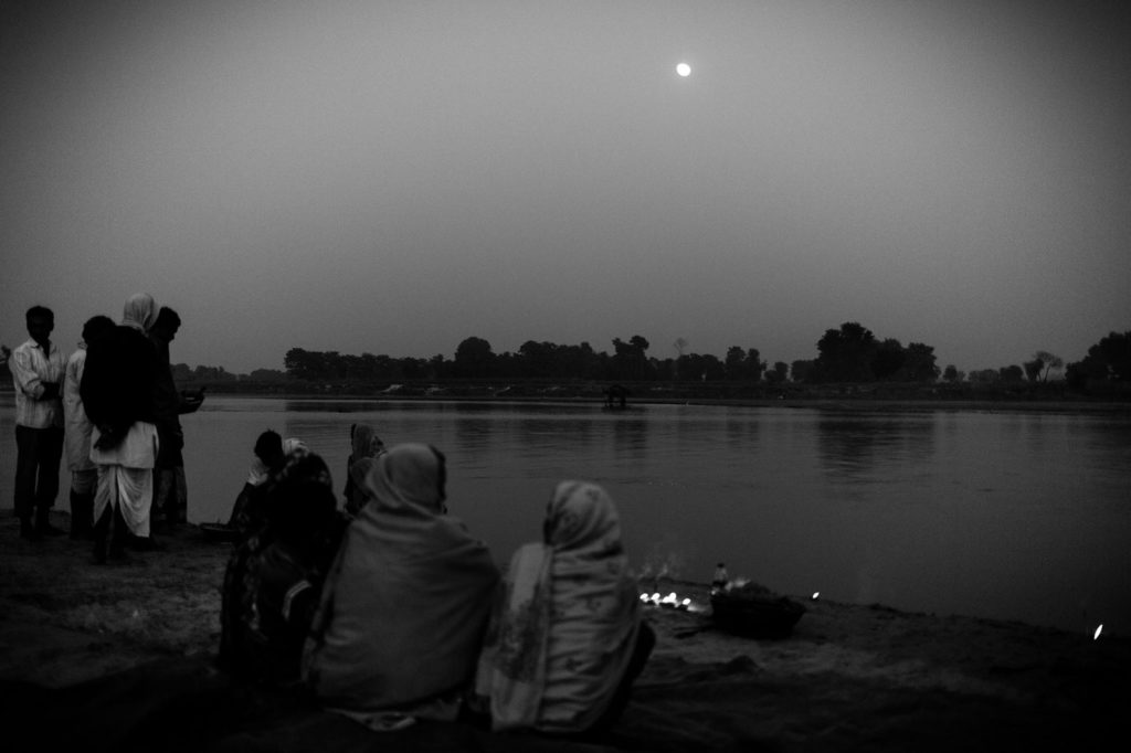 women in Nepal seated by waterfront