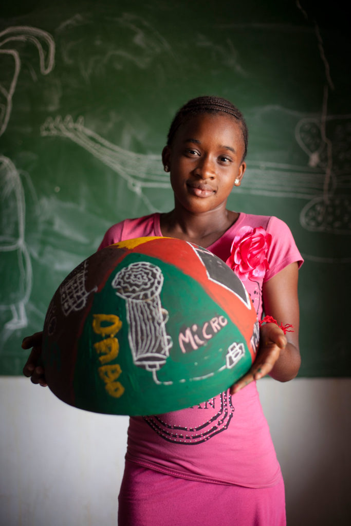 girl from Senegal holding painted bowl