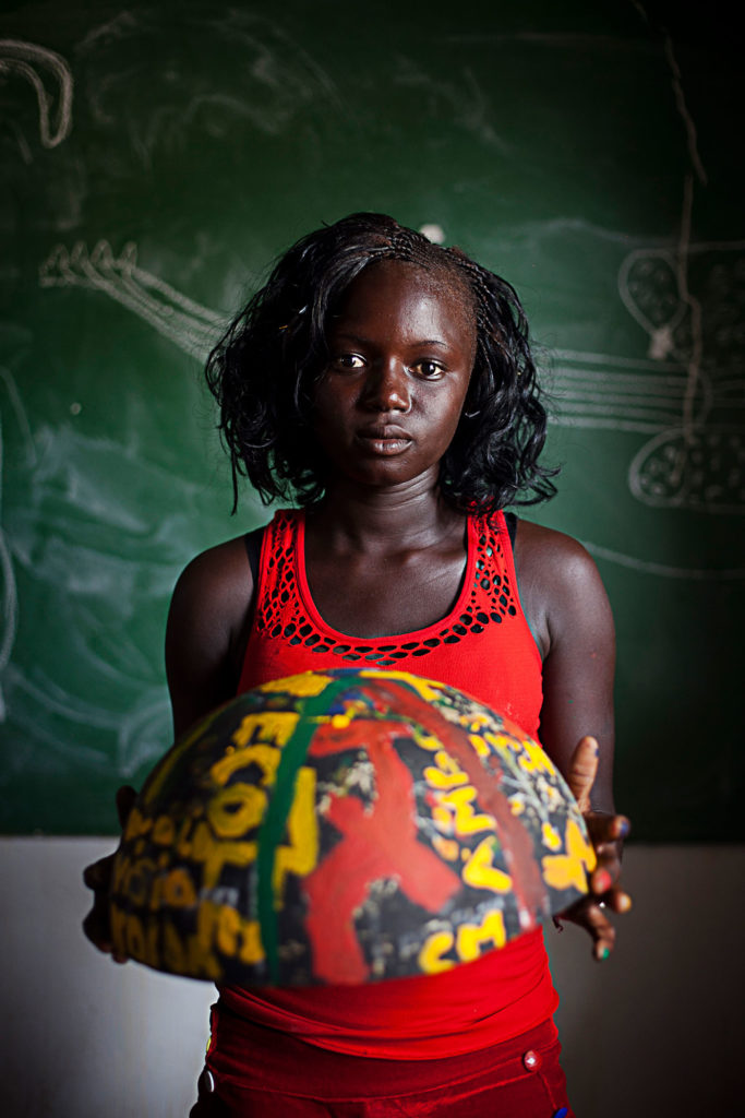 girl from Senegal holding painted bowl