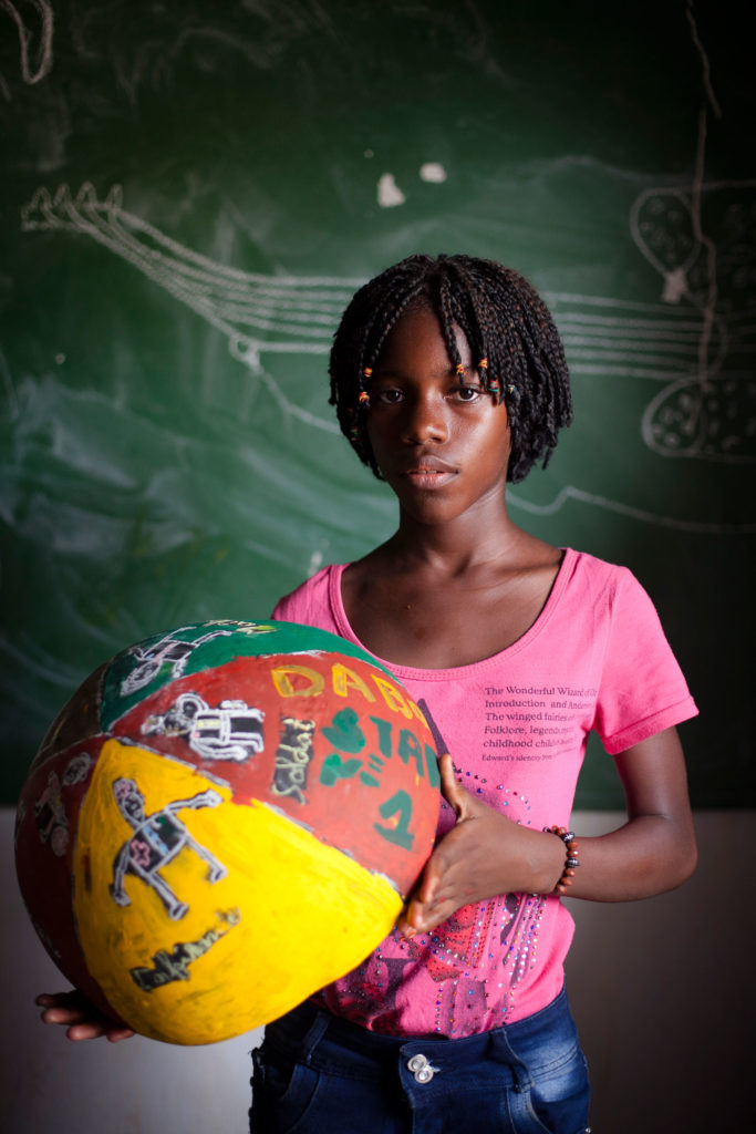 girl from Senegal holding painted bowl