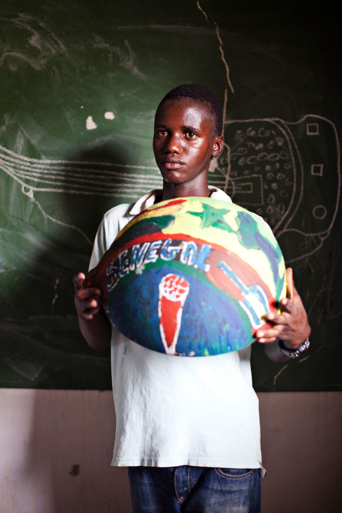 boy from Senegal holding painted bowl