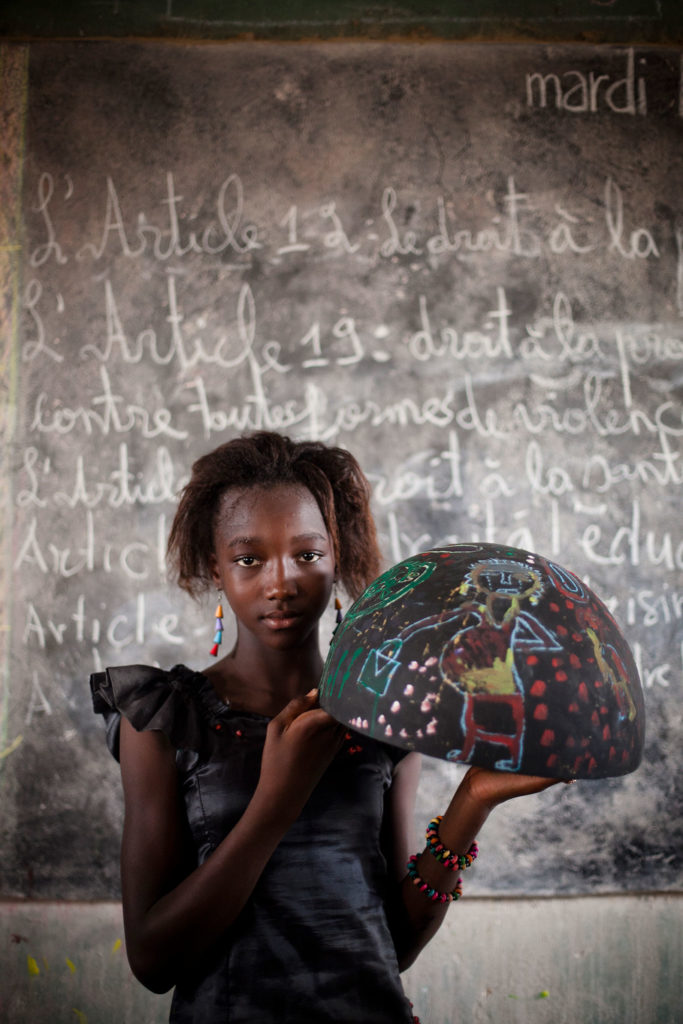 girl from Senegal holding painted bowl