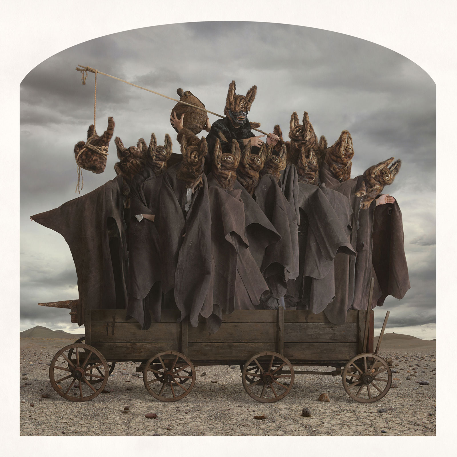 bat head masks and cloaks on vintage cart in desert landscape