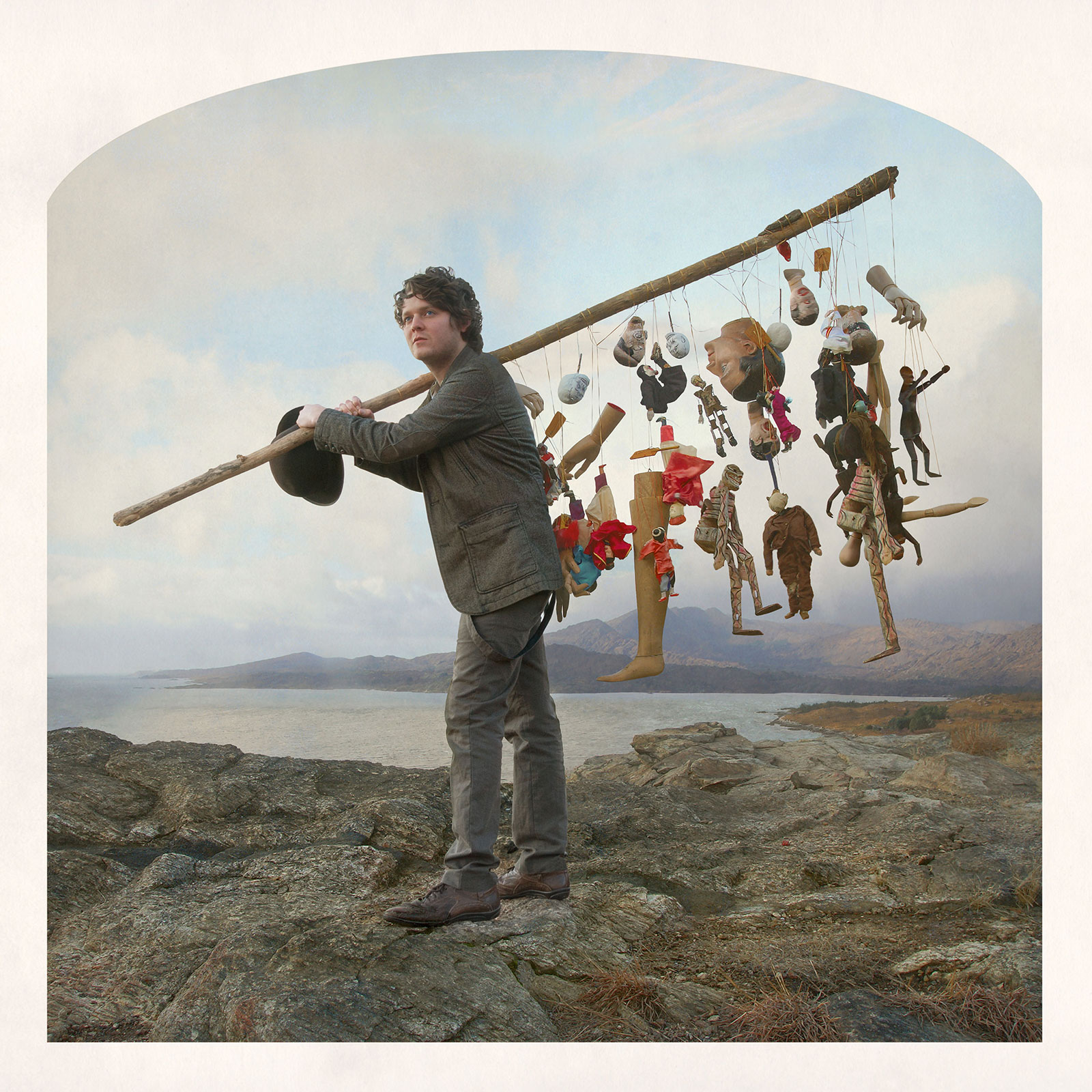 man in landscape with pole and puppets