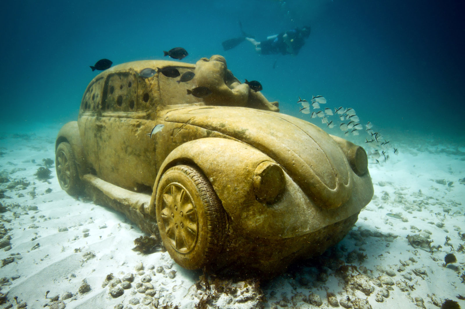 underwater sculpture of person on VW beetle